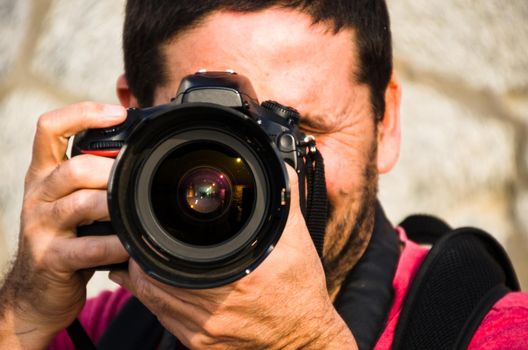 Photographer, taking photos with his professional camera with both hands