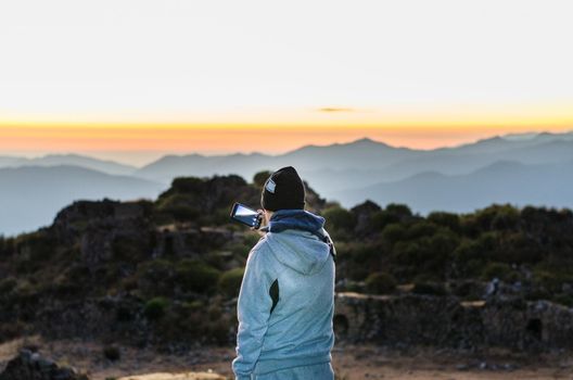 Young hiker with a smartphone on top of the mountain peak in Chiprac, Lima - Peru