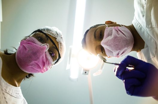 Portrait of two surgeons at work, operating in uniform, looking at the camera
