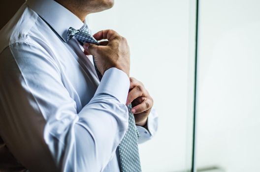 Businessman making a tie knot, formal suit