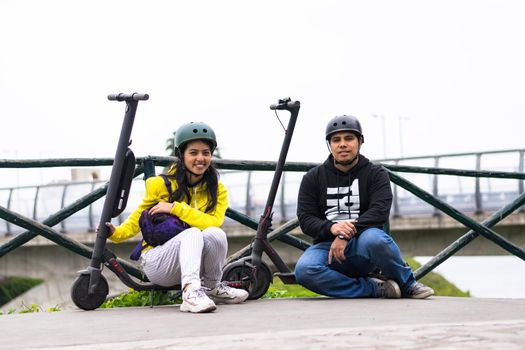 Two smiling friends showing helmet, concept in driving safety with a means of transportation