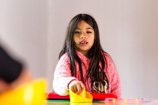 Concentrated and enthusiastic girl plays table hockey