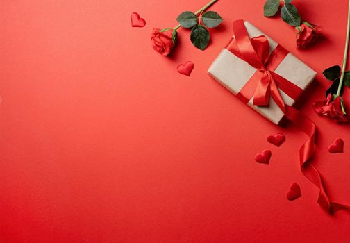 Red solid background with red hearts, gifts and confetti. The concept of Valentine Day.