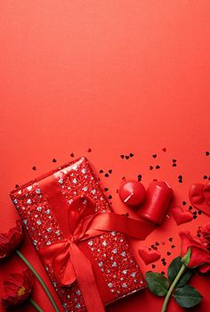 Red solid background with red hearts, gifts and candles. The concept of Valentine Day.