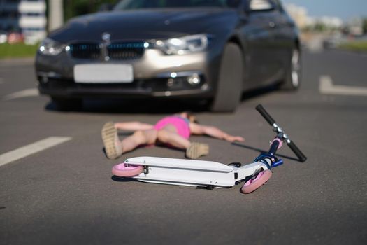 A child on a scooter was hit by a car, close-up, blurry. Trauma, death on the highway, road accident. Child alone in the street