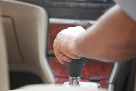 Male hand changing gear in the car
