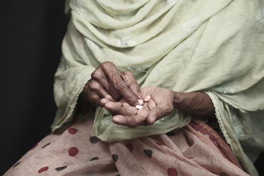 senior women hand's taking medicine, close up .