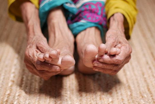 Close up on senior women feet and hand massage on injury spot