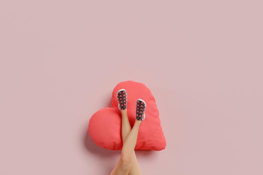 girl's legs resting on a heart shaped cushion. minimal concept of valentine, love and single. 3d rendering