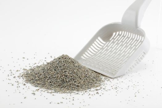 A scoop and heap of cat litter isolated on white