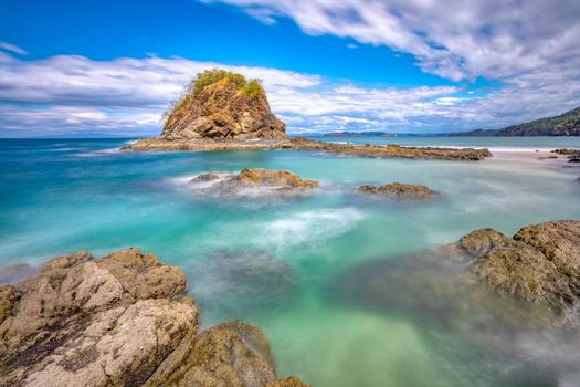 Long exposure, pacific ocean waves in Playa Ocotal, El Coco Costa Rica. Famous snorkel beach. Picturesque paradise tropical landscape of beach. Pura Vida concept, travel to exotic tropical country.