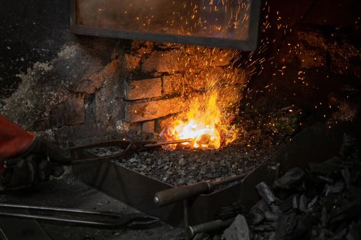 blacksmith warming blank metal on coal fire. High quality photo