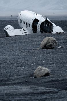 Rear view of abandoned airplane wreck with huge rocks