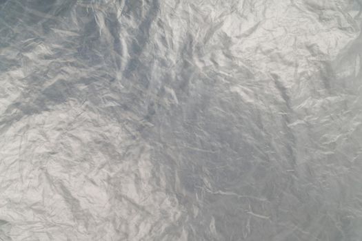 full frame background of flat crumpled semi-transparent polyethylene film.