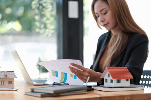 Business woman agent calculating loan of finance and investment for real estate, business woman and invest in property about home, construction or mortgage of home