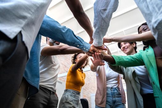 Multiracial coworkers join hands together in a circle. Business partners collaboration concept.