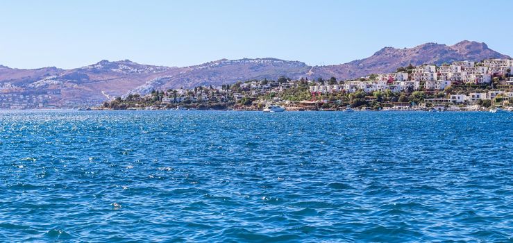 Blue sea sparkling in the sun. Beautiful coast with islands, mountains and yachts. Summer holidays concept