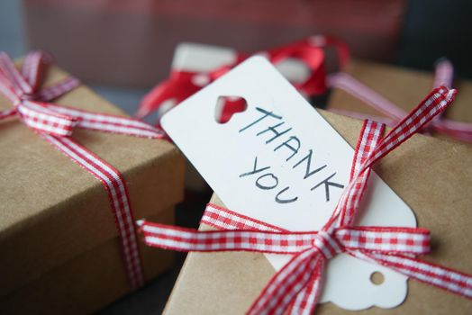 thank you note and gift box on table .
