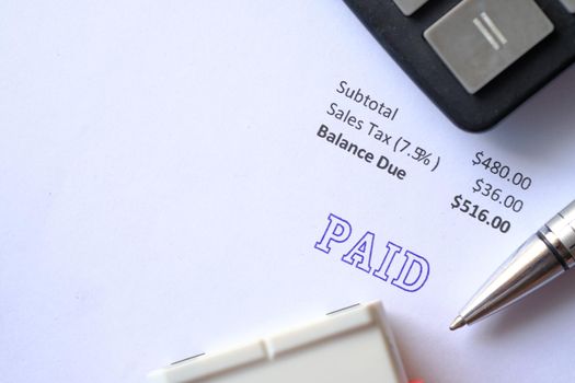 Paid invoice and Rubber Stamp on paper