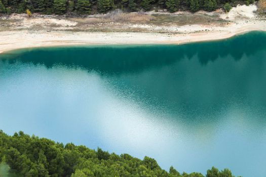 Reflections on the colorful swamp of Guadalest village surrounded by vegetation and mountains on a sunny day