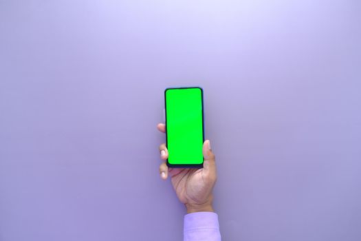 top view of young man hand using smart phone with green screen .