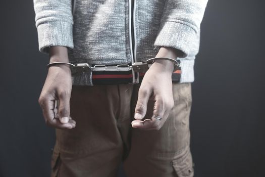 man's hand with handcuff on black background..