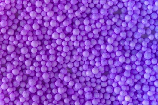 Color of the year 2022. Many light violet blue balls for children playground. Cosmetics powder. Candy sprinkles. Top view. Trendy abstract background or backplate for your design