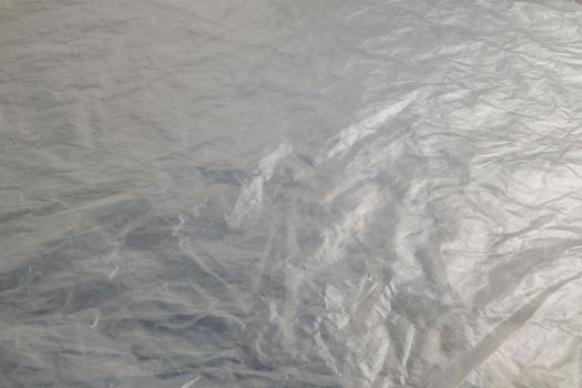 full frame background of flat crumpled semi-transparent polyethylene film.