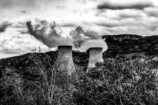 Smoking chimneys in Cofrentes nuclear power plant between mountains in Valencia, Spain