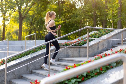 Sport and Fitness. Fit Woman Running up stairs Summer Sunny Morning Caucasian Athletic Female Jogging Outdoor Cardio Training Active Healthy Lifestyle Dressed Black Sportswear Motivation Concept