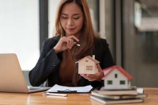 Business Financing Accounting Banking Concept, businesswoman doing finances and calculate about cost to real estate investment and tax.
