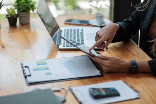 Close up business woman hands holds tablet pad while calculating charts profit and calculating financial report. business financial concept.