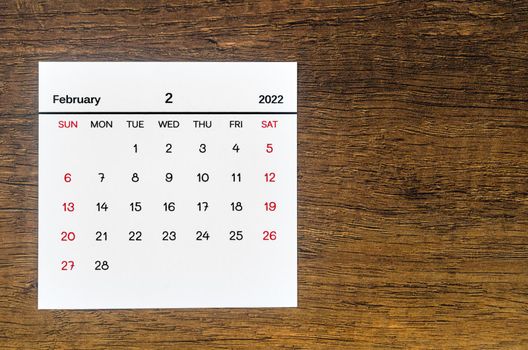 The February 2022 calendar on vintage wooden background.