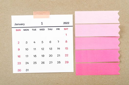 January calendar with blank adhesive note paper on brown background.