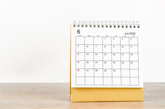 The June 2022 desk calendar on wooden table.