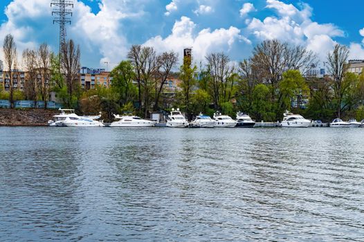Mooring place for river pleasure boats on the Dnieper River. Parking place for boats. Ship pier. Bank of the river. Coastline. Water transport. Dnieper river in Kiev. Water stream.