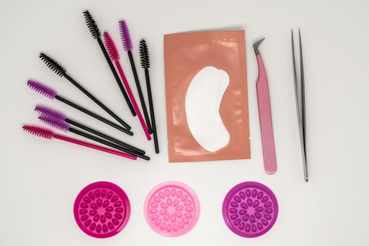 Eyelash extension tools, eyelash combs and eyelashes on a white background