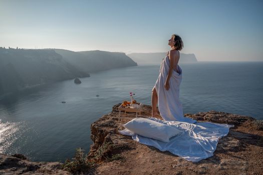 Woman wake up in bed wuth duvet and pillow over nature sea background outdoors. Back view. Good morning. Freedom concept