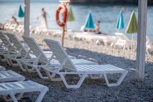 white sun loungers and an umbrella on a deserted beach. The perfect vacation concept