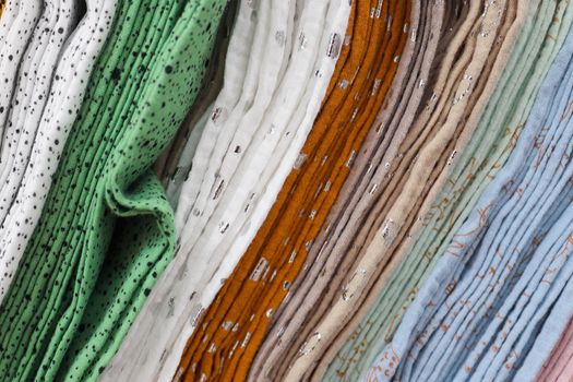 Detailed close up view on samples of cloth and fabrics in different colors found at a fabrics market.