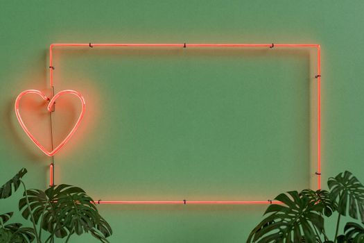 neon frame with a heart on green wall with plants in front. valentine's day concept, home, greeting card and decoration. 3d rendering