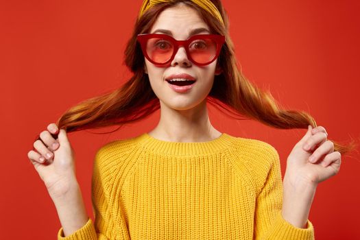 woman holding hair in red glasses fashion studio retro style. High quality photo