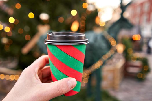 closeup cup of mulled wine with blurred background of winter wonderland, a Christmas Market in European small city.