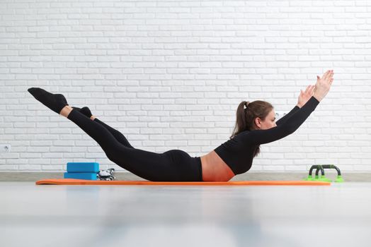 girl conducts a home workout stretching to strengthen her back