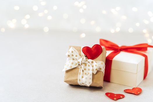 Gift or present box with red bow and heart shape on lights background. Copy space for text and design. Valentine day gift. Banner for Christmas, hew year, birthday concept.