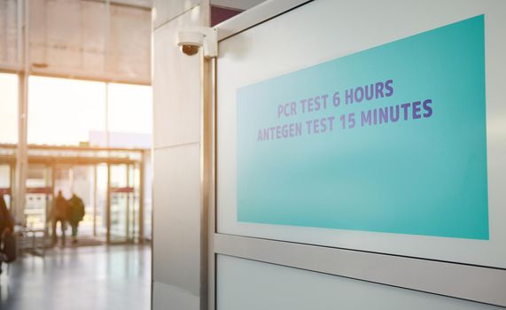A sign on the door with the inscription PCR test and Rapid antigen test in a test center at the terminal of the international airport for withdrawal from self-isolation upon arrival in the country