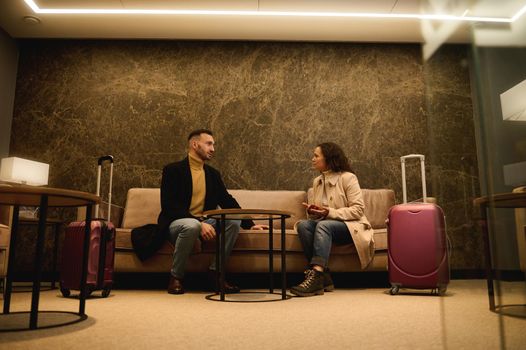 Business partners, businessman and businesswoman negotiating in a private meeting room in the airport departure terminal meeting room while waiting to board a flight during a business trip.