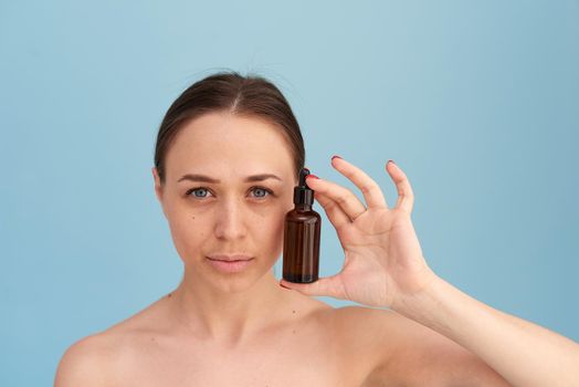 Skin Care. Beauty Portrait Of Woman Holding Bottle With Dropper Near Face.