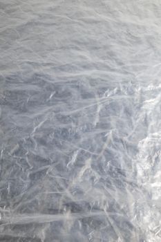 full frame background of flat crumpled semi-transparent polyethylene film.
