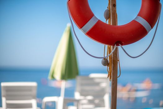 Several white sun loungers and a life buoy on a deserted beach. The perfect vacation concept.